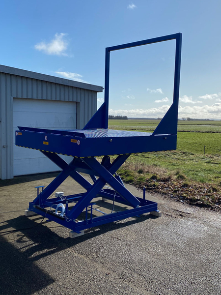 Scissor lift with fixed goal post barrier and auto-rising roll off stop